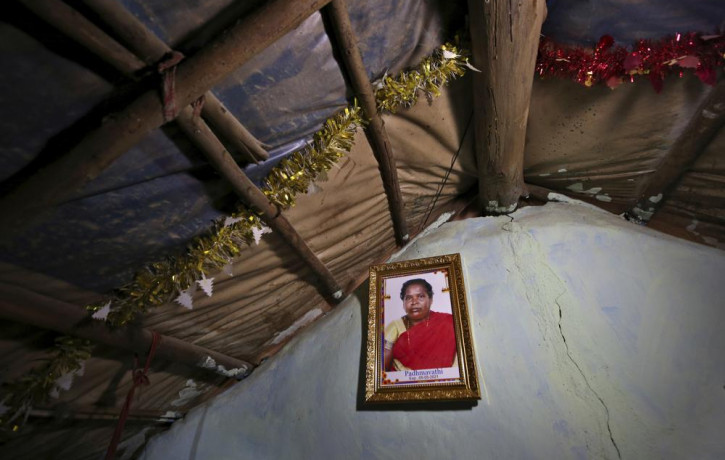 A portrait of Padmavathi, who died of COVID-19, hangs on the wall of her family hut made from bamboo and plastic sheeting in a slum in Bengaluru, India, Thursday, May 20, 2021.