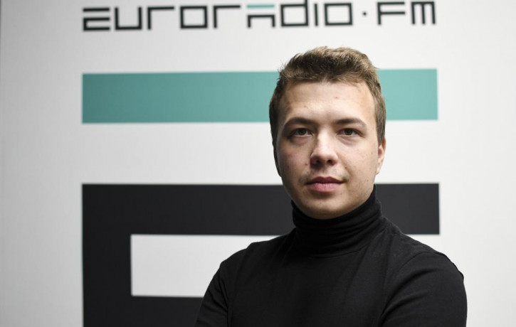 In this handout photo released by European Radio for Belarus, Belarus journalist Raman Pratasevich poses for a photo in front of euroradio.fm sign in Minsk, Belarus, Sunday, Nov. 17, 2019.