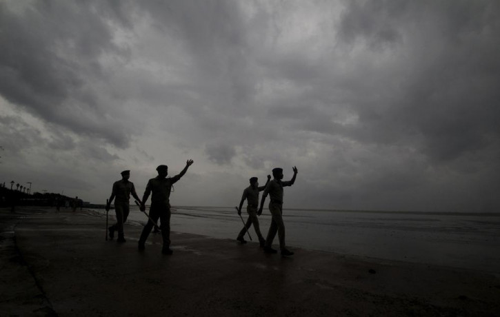 Policemen ask people to move to cyclone shelters as they patrol a beach in Balasore district in Odisha, India, Tuesday, May 25, 2021.