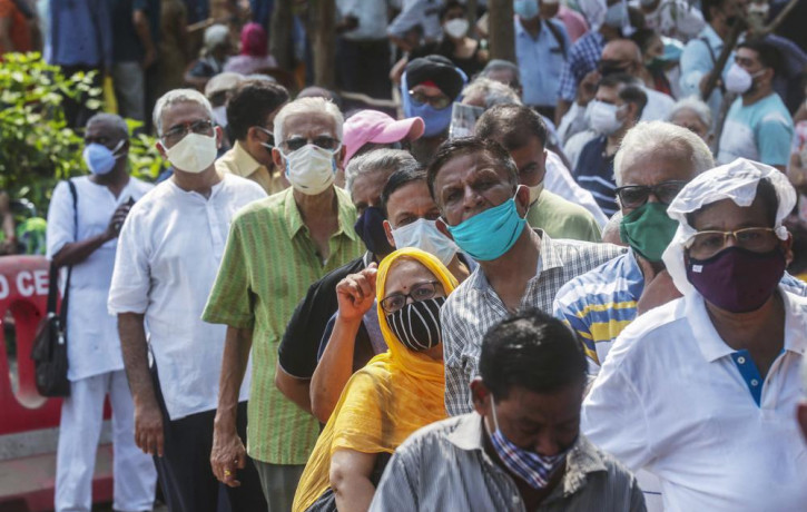 In this April 26, 2021, file photo, people queue up for coronavirus vaccine in Mumbai, India.