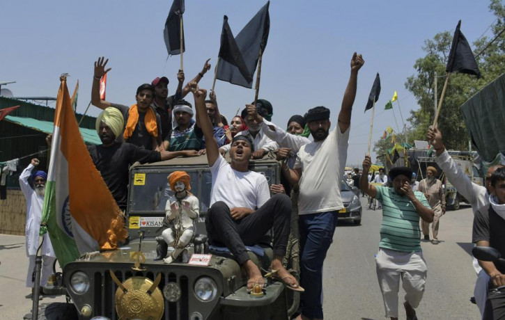 Farmers, some carrying black flags, on a vehicle during a protest in Ghazipur, outskirts of New Delhi, India, Wednesday, May 26, 2021.