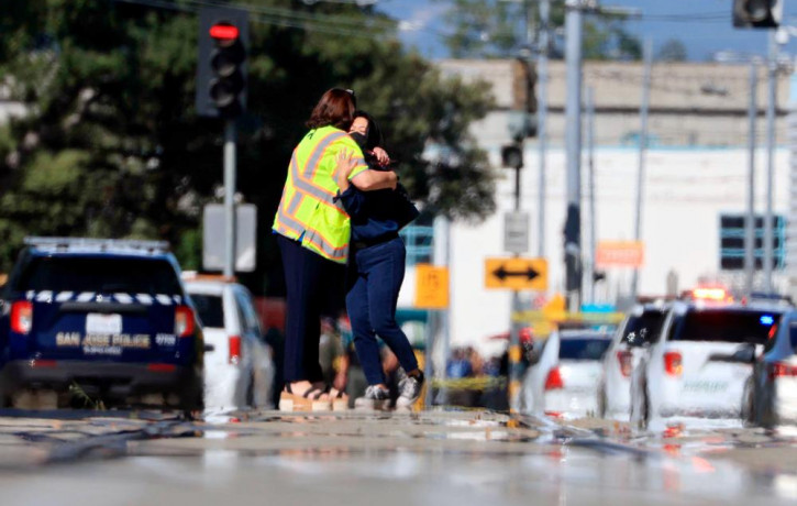 Two people hug on Younger Avenue outside the scene of a shooting in San Jose, Calif., on Wednesday, May, 26. 2021.