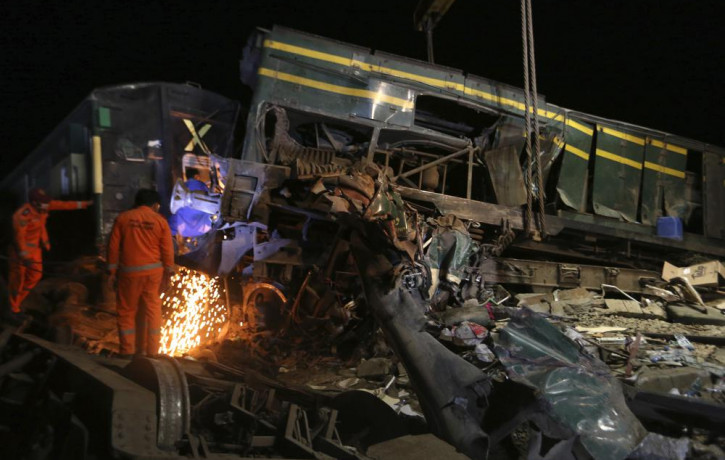 Railway workers try to clear the track at the site of a train collision in the Ghotki district, southern Pakistan, late Monday, June 7, 2021.