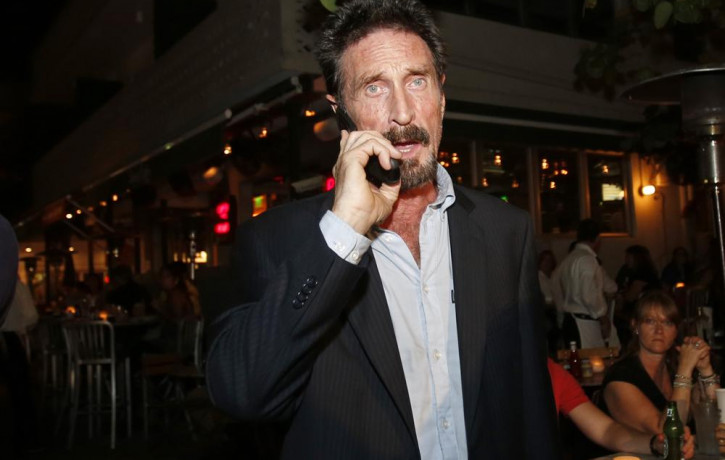 In this Dec 12, 2012 file photo, anti-virus software founder John McAfee talks on his mobile phone as he walks on Ocean Drive in the South Beach area of Miami Beach, Florida.