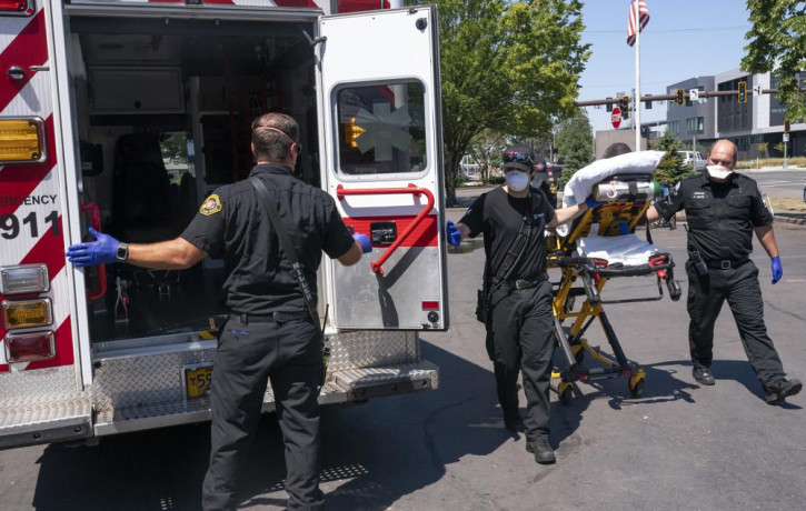 Salem Fire Department paramedics and employees of Falck Northwest ambulances respond to a heat exposure call during a heat wave, Saturday, June 26, 2021, in Salem, Oregon.