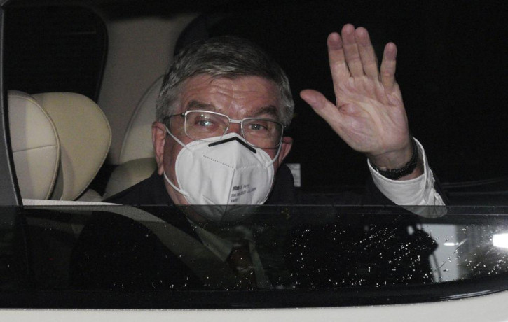 International Olympic Committee (IOC) President Thomas Bach waves from the vehicle to media upon his arrival an accommodation Thursday, July 8, 2021, in Tokyo.