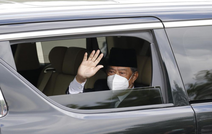 Embattled Malaysian Prime Minister Muhyiddin Yassin waves from a car while entering the National Palace to meet with the King in Kuala Lumpur, Malaysia, Monday, Aug. 16, 2021.