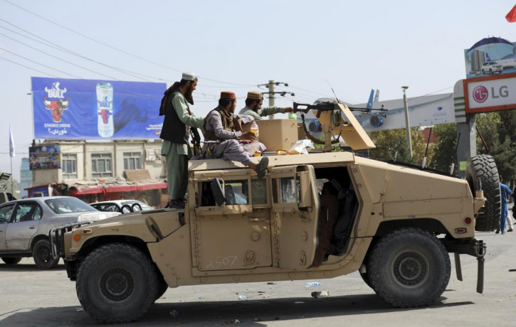 Taliban fighters stand guard in front of the Hamid Karzai International Airport, in Kabul, Afghanistan, Monday, Aug. 16, 2021.