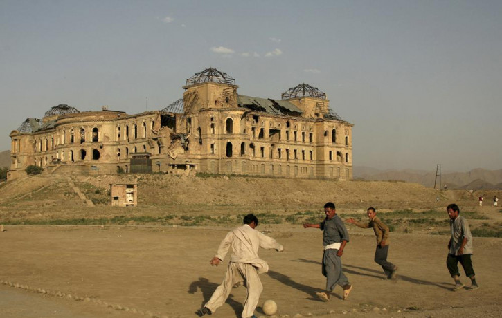 In this July 1, 2008 file photo, Afghans play football in front of the destroyed Darul Aman Palace in the western part of Kabul, Afghanistan.