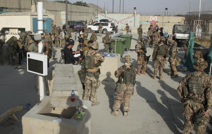 In this photo provided by the Ministry of Defence, members of the British and US military engage in the evacuation of people out of Kabul, Afghanistan on Friday, Aug. 20, 2021.