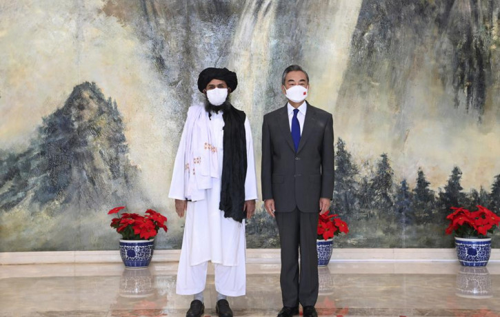 In this July 28, 2021, file photo released by China's Xinhua News Agency, Taliban co-founder Mullah Abdul Ghani Baradar, left, and Chinese Foreign Minister Wang Yi pose for a photo during the