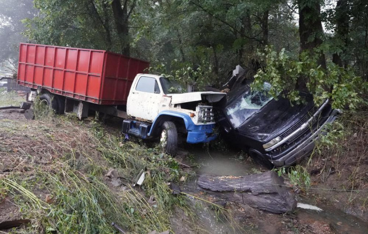 A truck and a car sit in a creek Sunday, Aug. 22, 2021, after they were washed away the day before in McEwen, Tennessee.