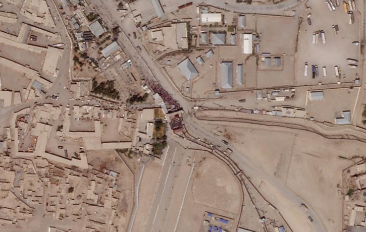 In this satellite photo taken by Planet Labs Inc., a massive crowd is seen at the gate marking the border crossing between Spin Boldak, Afghanistan, and Chaman, Pakistan, Thursday, Aug. 26, 2