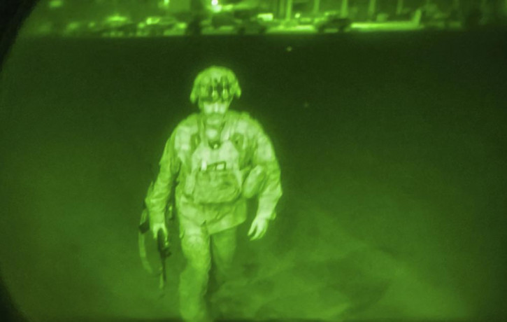 In this image made through a night vision scope and provided by U.S. Central Command, XVIII Airborne Corps, boards a C-17 cargo plane at the Hamid Karzai International Airport in Kabul, Afgha