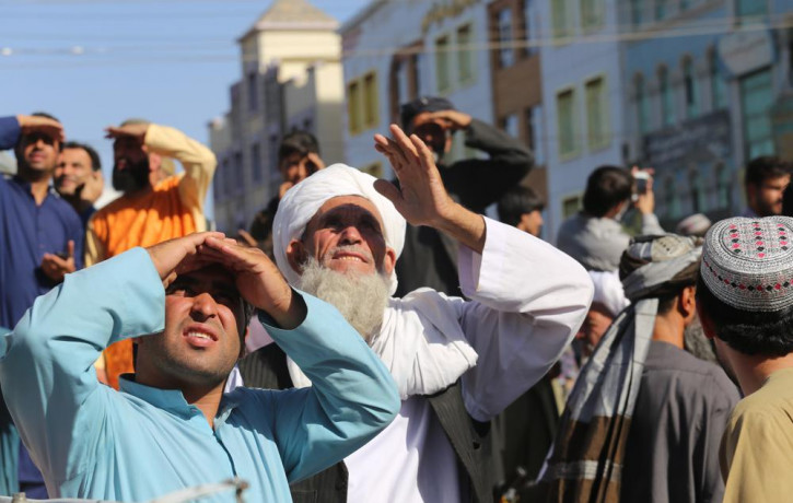 People look up at a dead body hanged by the Taliban from a crane in the main square of Herat city in western Afghanistan, on Saturday Sept. 25, 2021.