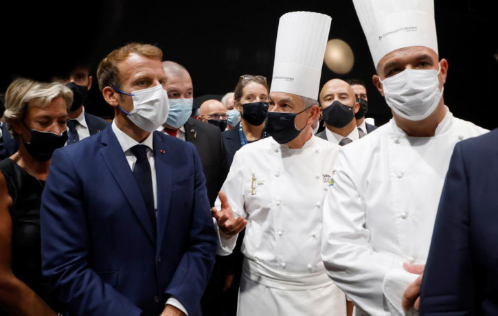French President Emmanuel Macron, left, speaks with French chefs Regis Marcon, enter, and Jerome Bocuse, right, at the Bocuse d'Or gastronomy contest during the International Catering, Hotel 