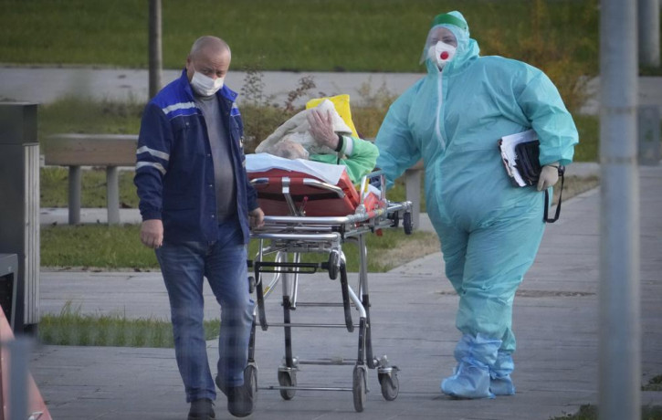 Medical workers carry a patient suspected of having coronavirus on a stretcher at a hospital in Kommunarka, outside Moscow, Russia, Monday, Oct. 11, 2021.