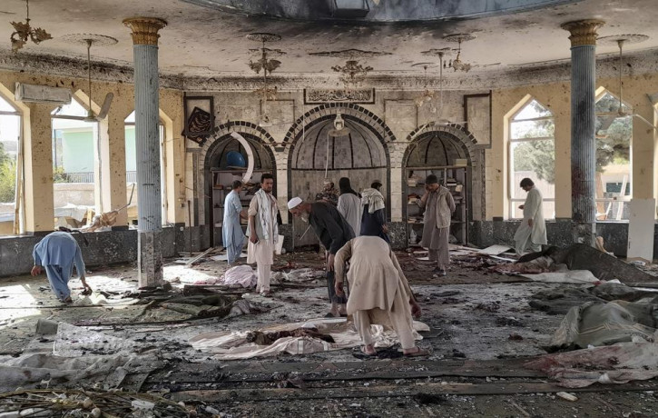 In this Oct. 8, 2021 file photo, people view the damage inside of a mosque frequented by the Shiite Muslim minority following a deadly bombing claimed by the Islamic State that killed dozens,