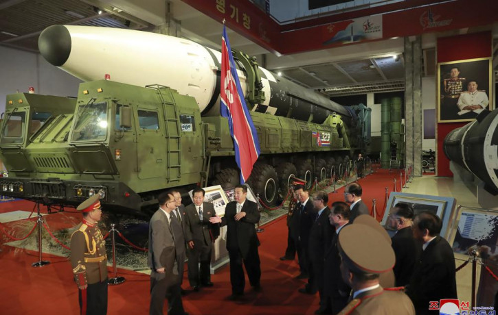 In this photo provided by the North Korean government, North Korean leader Kim Jong Un, center, speaks in front of what the North says an intercontinental ballistic missile displayed at an ex
