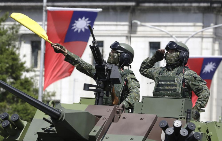 In this Oct. 10, 2021, file photo, Taiwanese soldiers salute during National Day celebrations in front of the Presidential Building in Taipei, Taiwan.