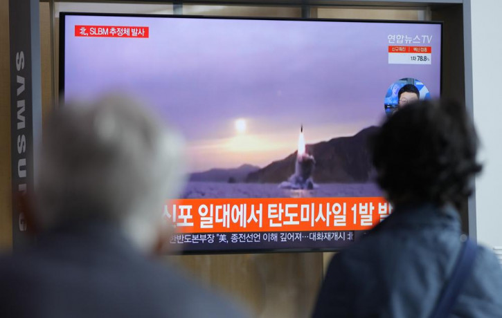 People watch a TV screen showing a news program reporting about North Korea's missile launch with file footage at a train station in Seoul, South Korea, Tuesday, Oct. 19, 2021.