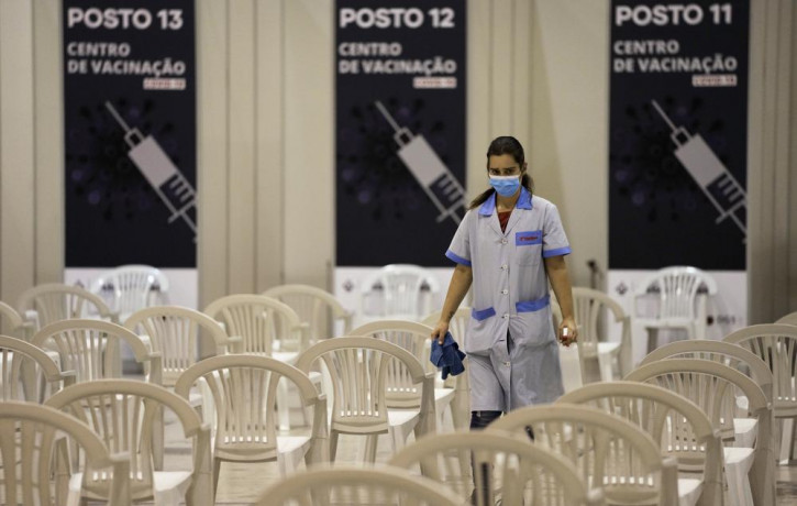 A worker disinfects chairs at a new vaccination center in Lisbon, Tuesday, Nov. 30, 2021.