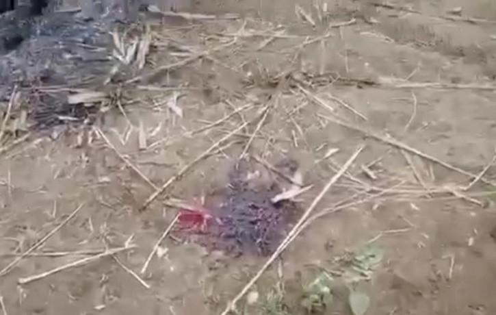 In this image from video taken Dec. 7, 2021, bloodstain is seen on the ground near charred corpses in Done Taw village in the Sagaing region of Myanmar.