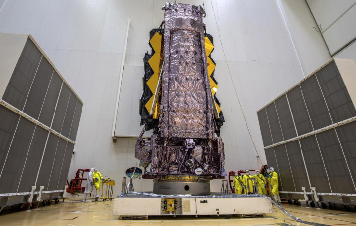 In this Saturday, Dec. 11, 2021 photo released by the European Space Agency, NASA's James Webb Space Telescope is secured on top of the Ariane 5 rocket that will launch it to space from Europ