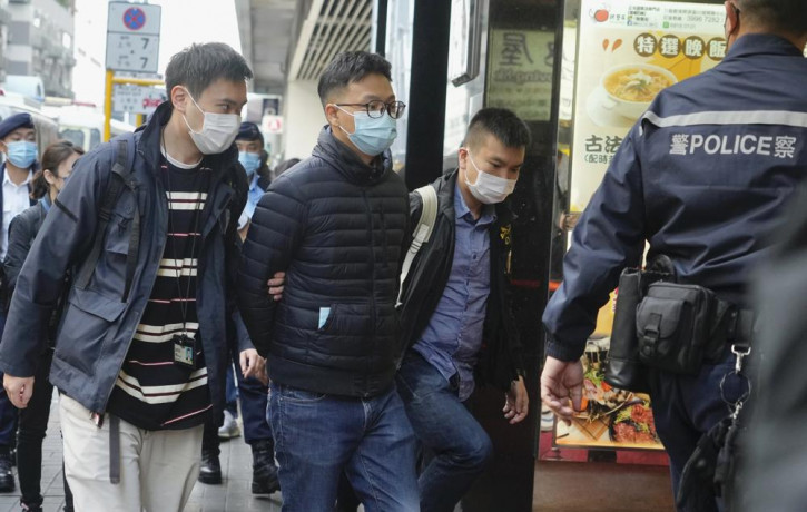 Editor of "Stand News" Patrick Lam, second from left, is arrested by police officers in Hong Kong, Wednesday, Dec. 29, 2021.