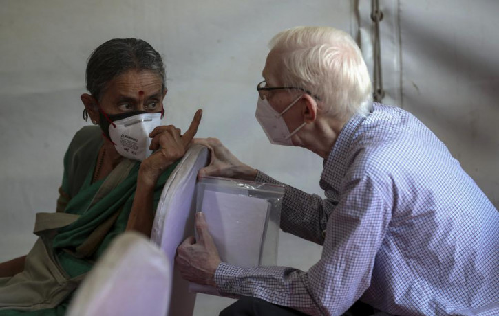Elderly people chat as they wait to receive the third dose of COVID-19 vaccine at a vaccination center in Bengaluru, India, Monday, Jan. 10, 2022.