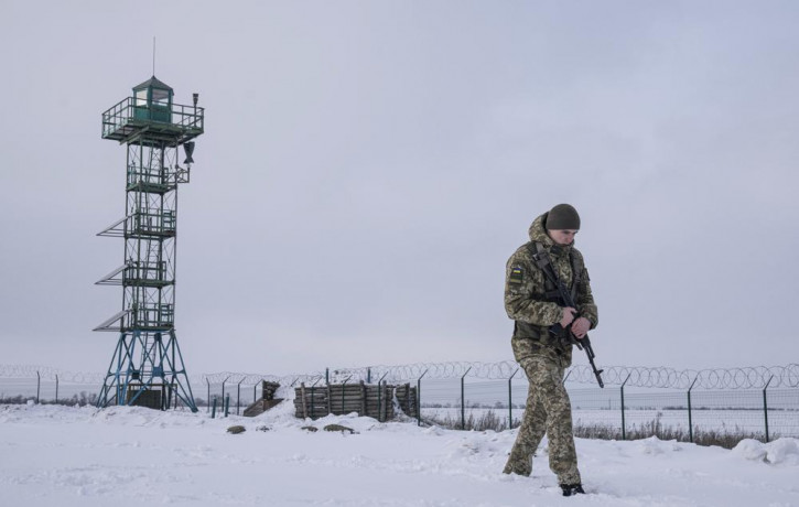 A Ukrainian border guard patrols the border with Russia not far from Hoptivka village, Kharkiv region, Ukraine, Wednesday, Feb. 2, 2022.