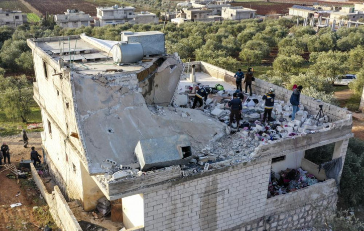 People inspect a destroyed house following an operation by the U.S. military in the Syrian village of Atmeh, in Idlib province, Syria, Thursday, Feb. 3, 2022.