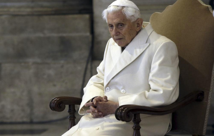 This Dec. 8, 2015 file photo shows Pope Emeritus Benedict XVI sitting in St. Peter's Basilica as he attends the ceremony marking the start of the Holy Year.