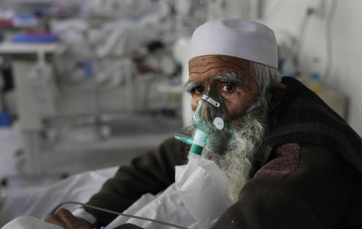 An Afghan patient infected with COVID-19 sits on a bed in the intensive care unit of the Afghan Japan Communicable Disease Hospital, in Kabul, Afghanistan, Monday, Feb. 7, 2022.