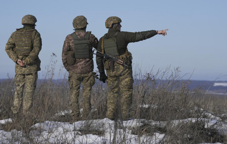 Ukrainian servicemen survey the impact areas from shells that landed close to their positions during the night on a front line outside Popasna, Luhansk region, eastern Ukraine, Monday, Feb. 1