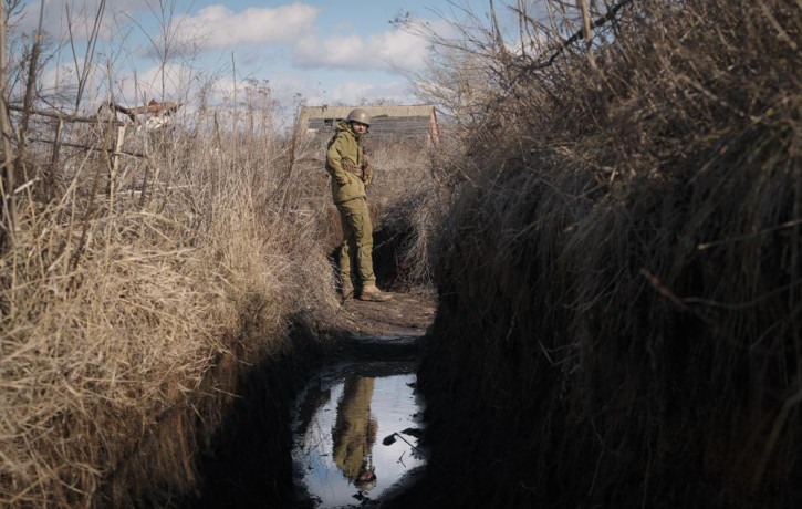 A Ukrainian serviceman pauses while walking to a frontline position outside Popasna, in the Luhansk region, eastern Ukraine, Sunday, Feb. 20, 2022.