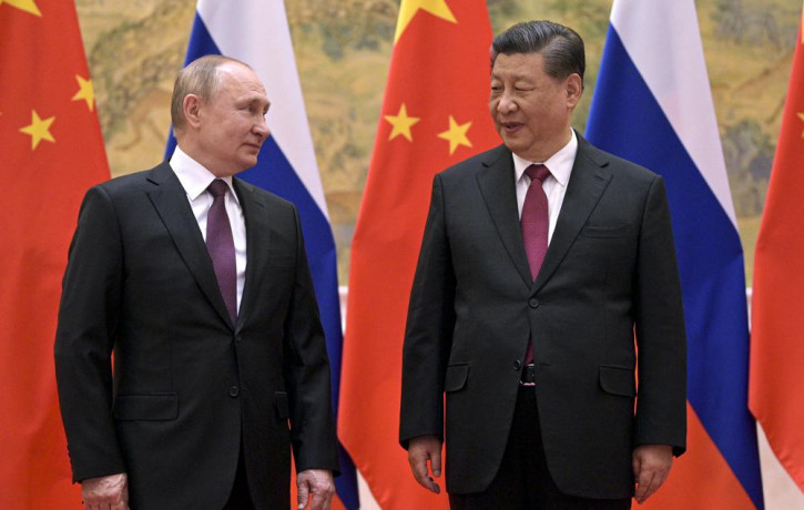 Chinese President Xi Jinping, right, and Russian President Vladimir Putin talk to each other during their meeting in Beijing, Friday, Feb. 4, 2022.