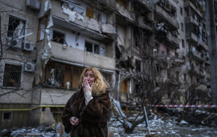 Natali Sevriukova reacts next to her house following a rocket attack the city of Kyiv, Ukraine, Friday, Feb. 25, 2022.