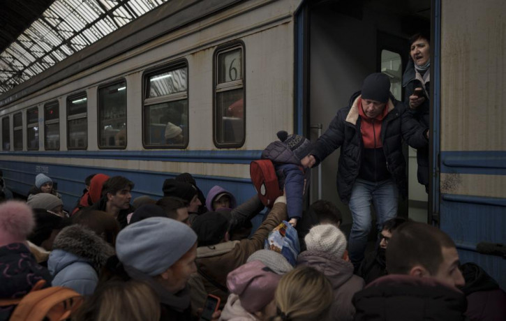 Passengers rush to board a train leaving to Slovakia from the Lviv railway station, in Lviv, west Ukraine, Wednesday, March 2, 2022.