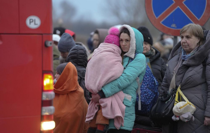 Refugees, mostly women with children, wait for transportation at the border crossing in Medyka, Poland, Saturday, March 5, 2022, after fleeing from the Ukraine.