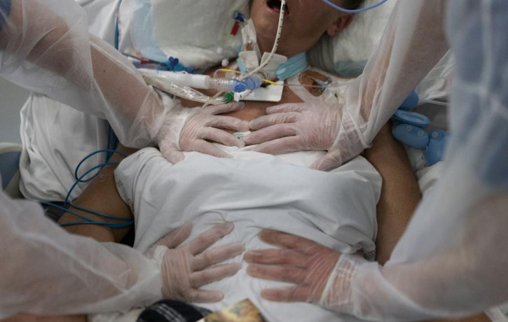 Nurses perform timed breathing exercises on a COVID-19 patient on a ventilator in the COVID-19 intensive care unit at the la Timone hospital in Marseille, southern France, Friday, Dec. 31, 20