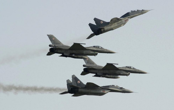 Two Polish Air Force Russian made Mig 29's fly above and below two Polish Air Force U.S. made F-16's fighter jets during the Air Show in Radom, Poland, on Aug. 27, 2011.