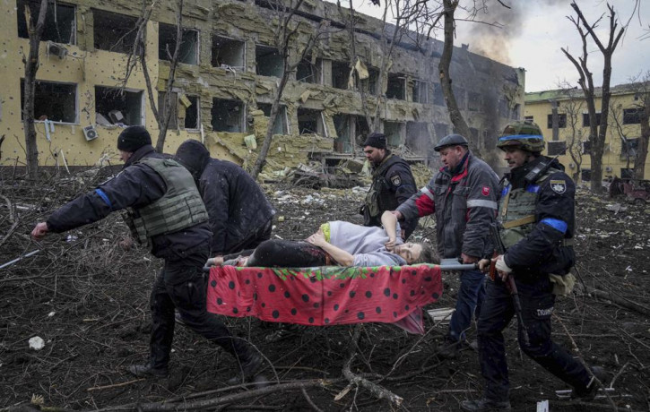 Ukrainian emergency employees and volunteers carry an injured pregnant woman from the damaged by shelling maternity hospital in Mariupol, Ukraine, Wednesday, March 9, 2022.