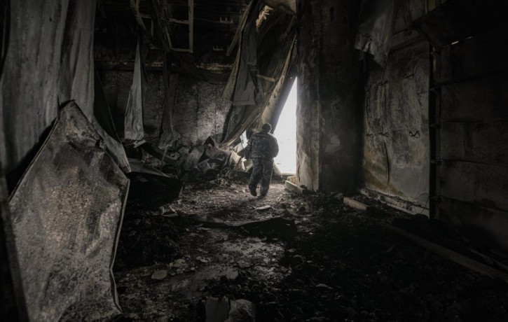 A staff member exits a large food products storage facility which was destroyed by an airstrike in the early morning hours in Brovary, north of Kyiv, Ukraine, Sunday, March 13, 2022.