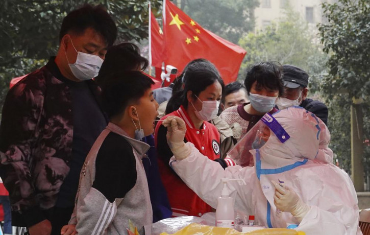 A medical worker takes a swab sample from a child for Covid-19 testing in a community in Changzhou in eastern China's Jiangsu province Monday, March 14, 2022.