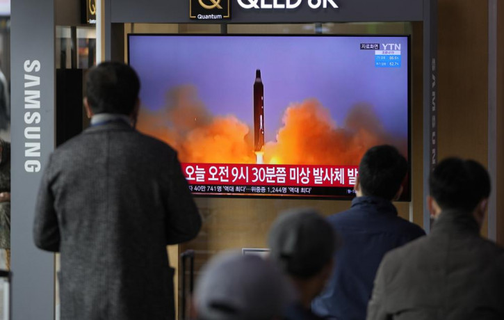People watch a TV screen showing a news program reporting about North Korea's missile with file footage, at a train station in Seoul, South Korea, Wednesday, March 16, 2022.
