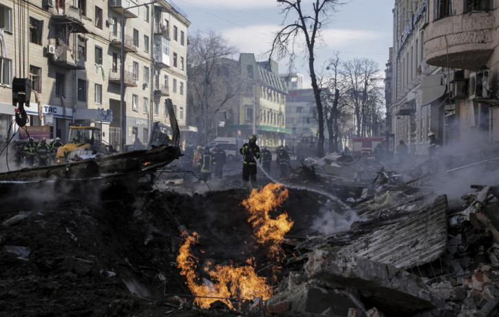 Firefighters extinguish flames outside an apartment house after a Russian rocket attack in Kharkiv, Ukraine's second-largest city, Ukraine, Monday, March 14, 2022.