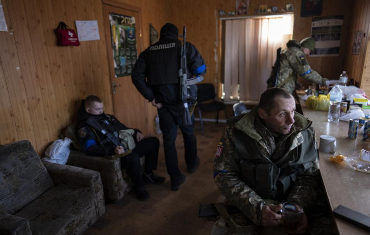 A soldier drinks tea during a break at a military check point, in Lityn, Ukraine, Wednesday, March 16, 2022.