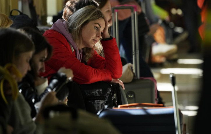 A woman waits for a transport after fleeing the war from neighboring Ukraine at a railway station in Przemysl, Poland, on Tuesday, March 22, 2022.