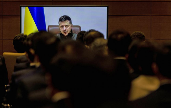 Members of Japan's lower house of parliament applaud as Ukrainian President Volodymyr Zelenskyy delivers a virtual address to Japanese lawmakers in Tokyo, Wednesday, March 23, 2022.